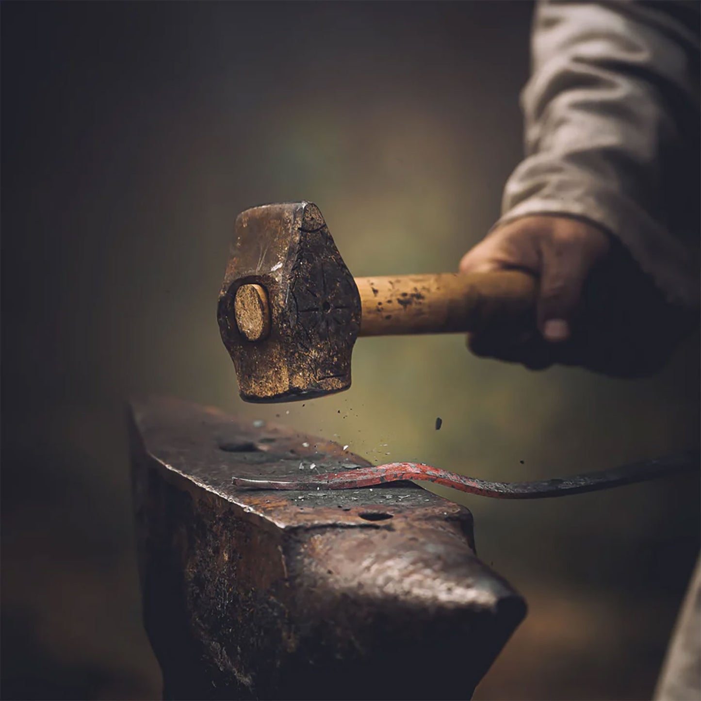 Blacksmith shaping iron on an anvil